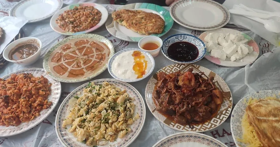 Ein Tisch voller kleiner Teller mit bahrainischen Gerichten, Brot und Dips